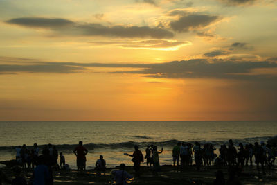 Photo moment when the sunset on the beach with people enjoying the beauty of the sun slowly sinking.