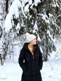 Woman standing against frozen tree