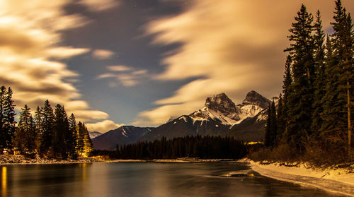 Scenic view of lake by mountains against sky during sunset