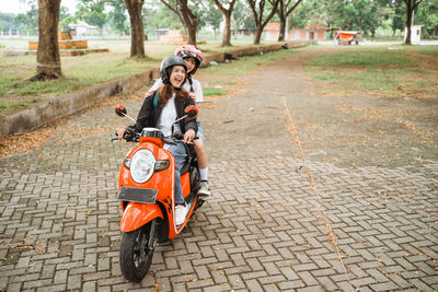 Man riding motor scooter on road