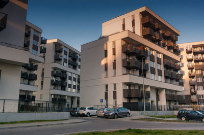Cars on road by buildings against sky