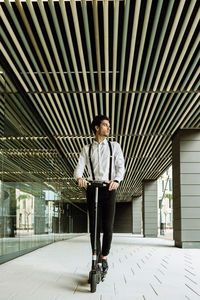 Portrait of young man standing against ceiling