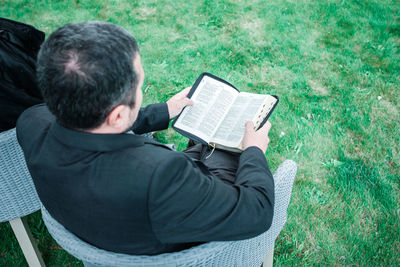 Rear view of man sitting on grass