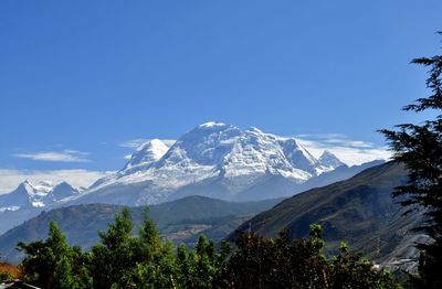 Scenic view of mountains against blue sky