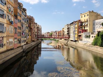 Canal amidst buildings in city against sky