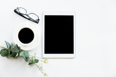 Directly above shot of coffee cup on table against white background