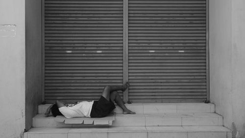 Side view of woman sleeping by closed window