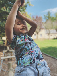 Midsection of smiling girl with arms raised