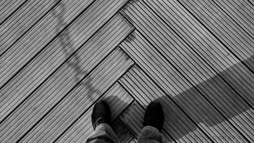 Low section of person standing on wooden floor