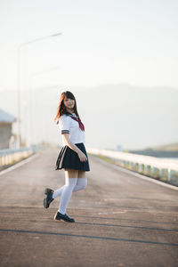 Portrait of smiling woman standing on bridge