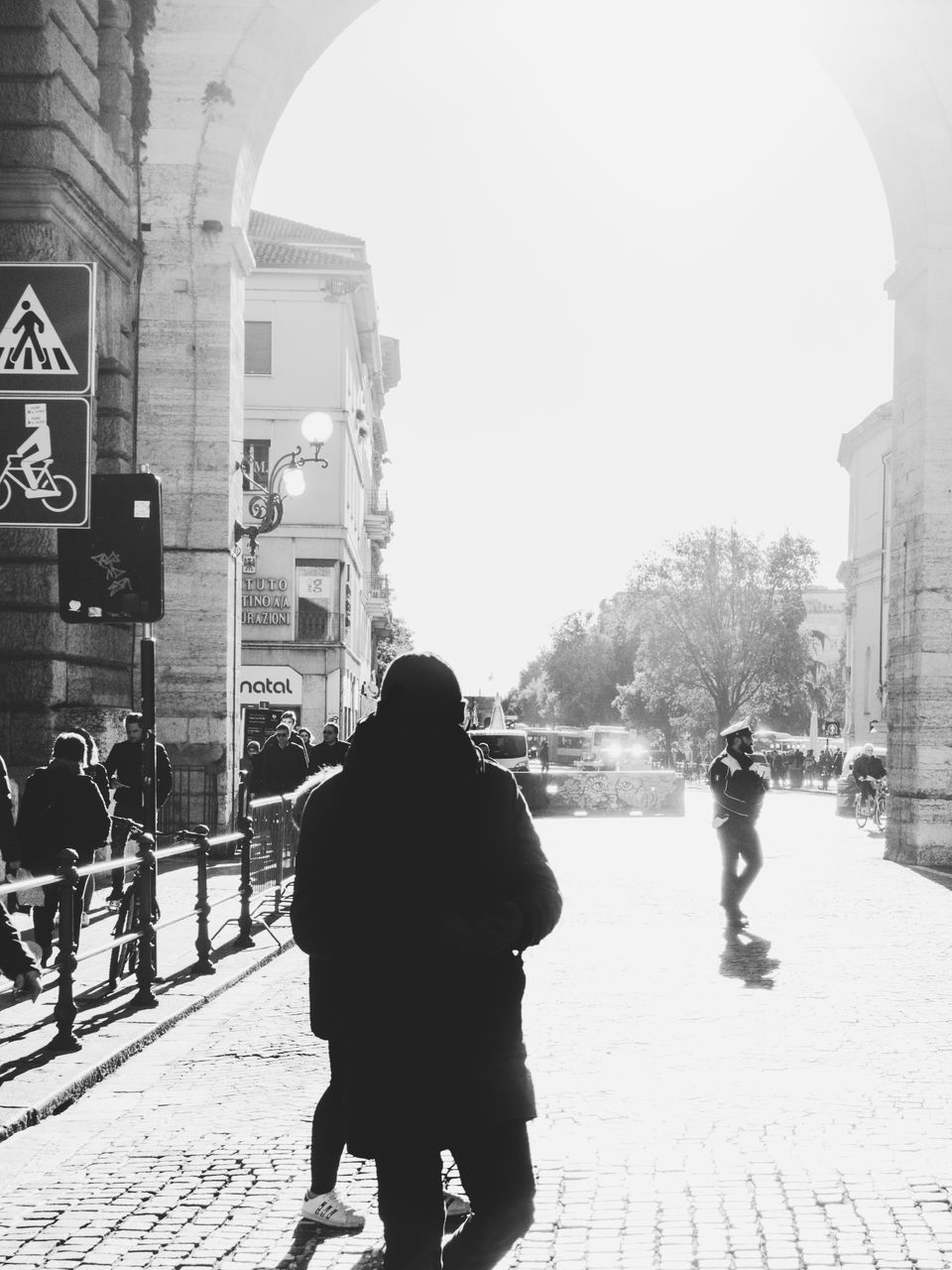 REAR VIEW OF WOMEN WALKING ON STREET IN CITY