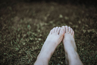 Low section of woman relaxing on field