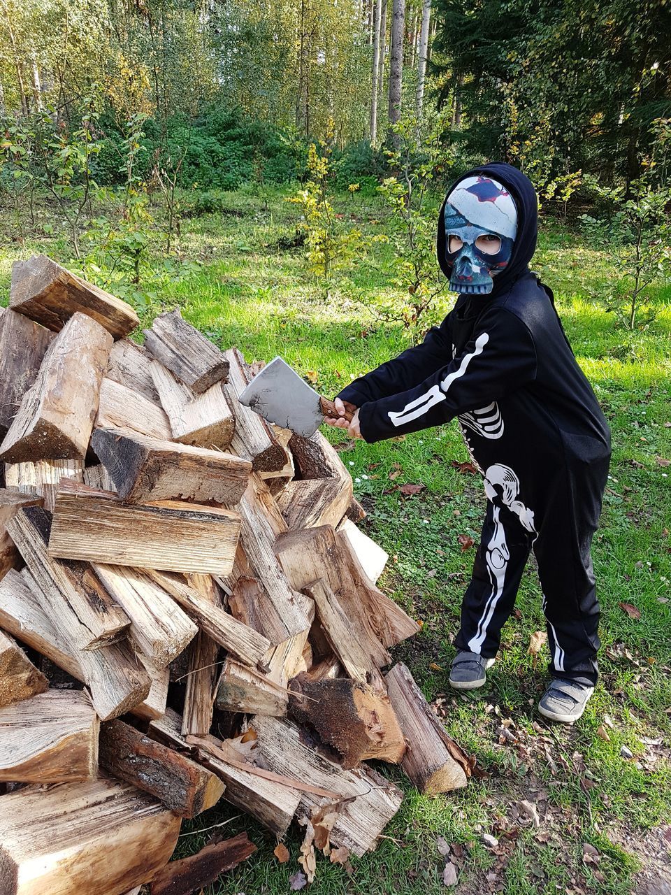 MAN STANDING BY LOGS IN FOREST