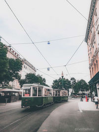 Cars on street in city against sky