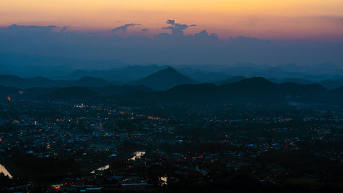 High angle shot of illuminated cityscape against sky at sunset