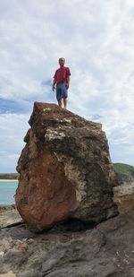 Full length of man standing on rock against sky