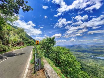 Road leading towards mountains against sky