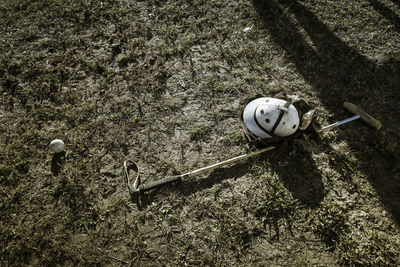High angle view of helmet with polo mallet and ball on field