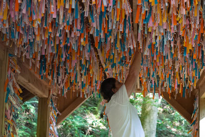 Senior man tying ribbon under wish of bridge