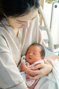 Close-up of cute baby girl lying on bed at home