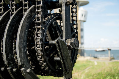 Close-up of machine part against sky