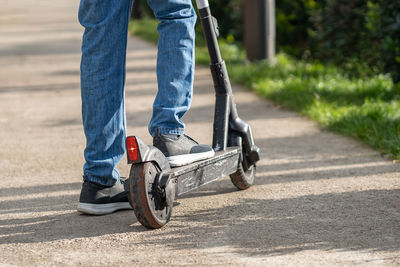 Low section of man skateboarding on road