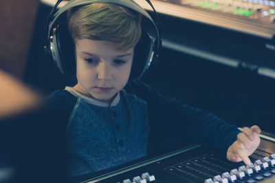 Cute boy mixing music in recording studio