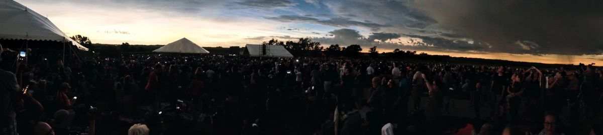 Panoramic view of crowd in front of sky during sunset