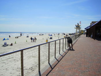 People on beach by sea against sky