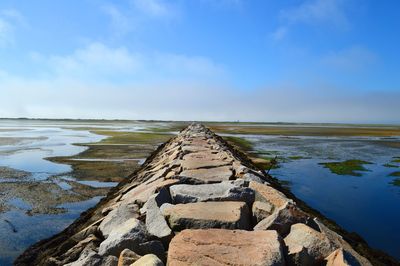 Jetty leading to calm blue sea