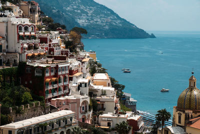 High angle view of townscape by sea against sky