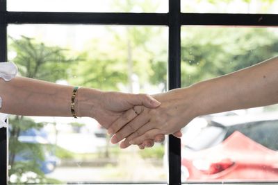 Close-up of woman hand holding window