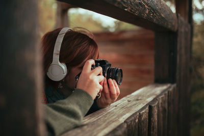 Portrait of woman photographing through camera