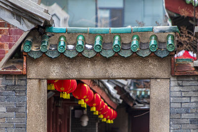 Low angle view of lanterns hanging on roof outside building