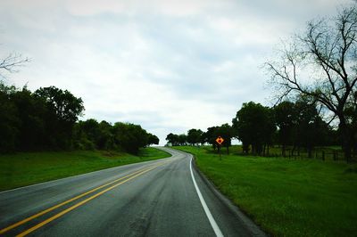 Empty road with trees in background