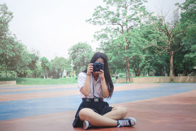 Man photographing against sky