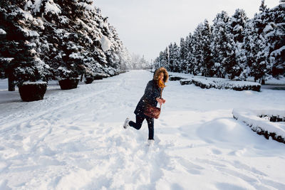 Rear view of person on snow field against sky