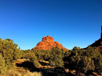 Rock formation on field against clear sky at big park