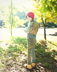 Boy standing on field during sunny day