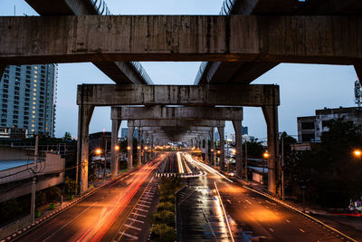 Traffic light trails on road in city against sky