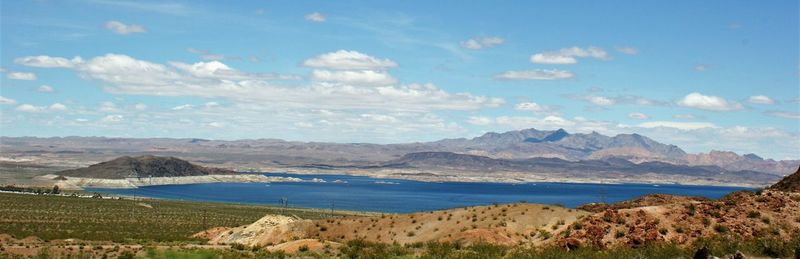 Scenic view of sea and mountains against sky