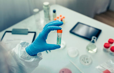 Cropped hand of scientist holding bottle in laboratory