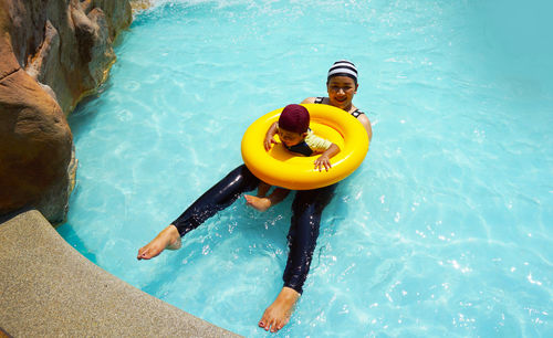 High angle view of woman with son in swimming pool at tourist resort