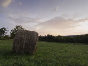 Hay bales on field against sky