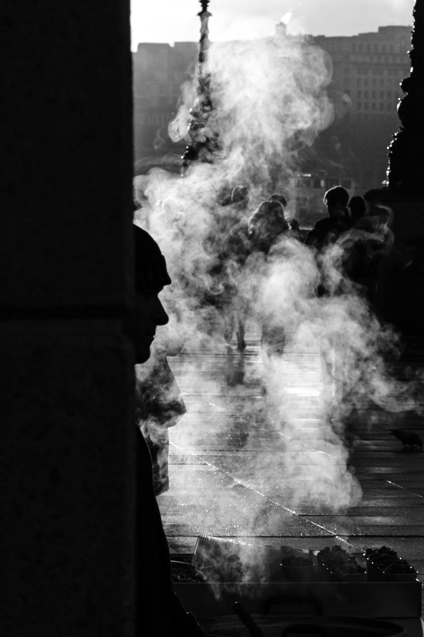 smoke - physical structure, belief, architecture, religion, built structure, spirituality, place of worship, smoke, real people, building exterior, incidental people, day, group of people, people, building, silhouette, motion