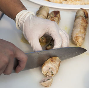 Cropped image of man cutting sausages