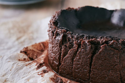 Close up of a chocolate basque burnt cheesecake on a wooden table