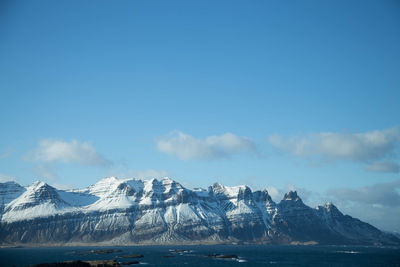 Scenic view of snowcapped mountains and sea against sky