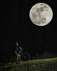 Full length of bicycle on field against sky at night