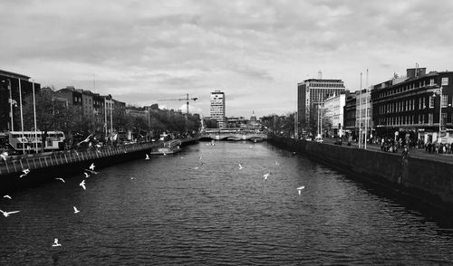 River amidst cityscape against sky